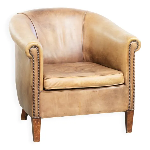 Fauteuil club en cuir vintage de style anglais dans une palette de couleurs claires.