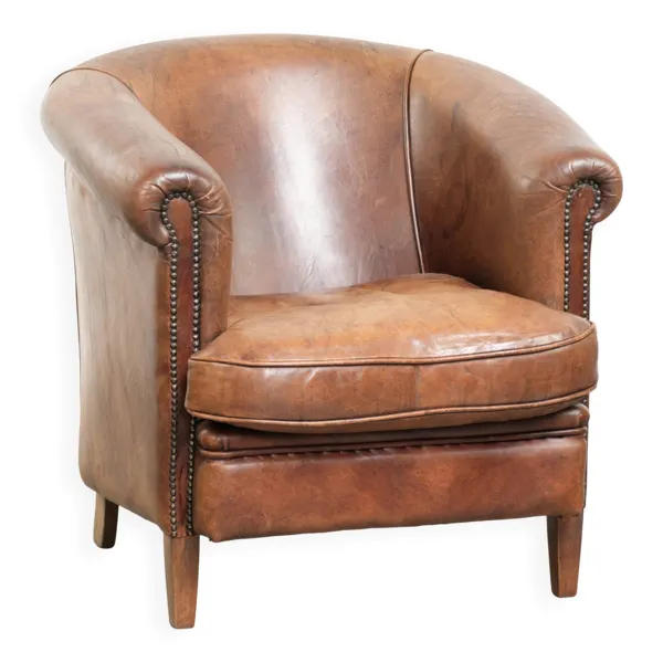 Fauteuil club en peau de mouton couleur cognac avec un look vintage de style anglais.