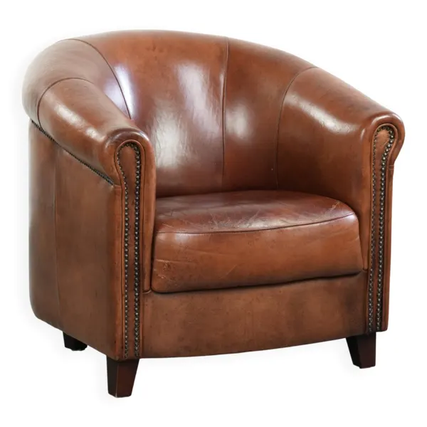 Fauteuil club en peau de mouton vintage de style anglais avec des couleurs profondes.