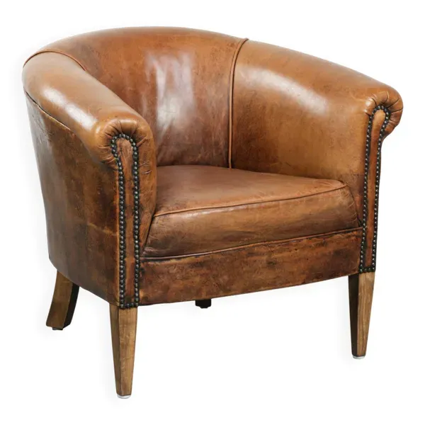 Fauteuil club en peau de mouton vintage dans une taille subtile avec des couleurs chaudes.