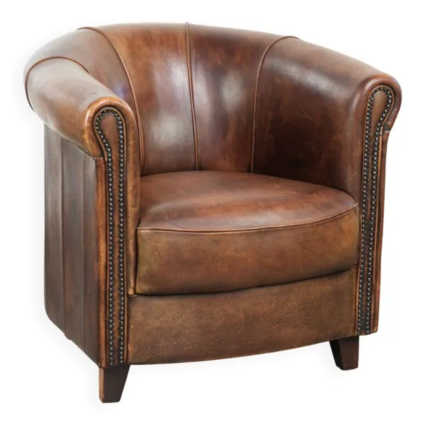 Fauteuil club en peau de mouton avec une belle patine, fini avec des clous décoratifs.