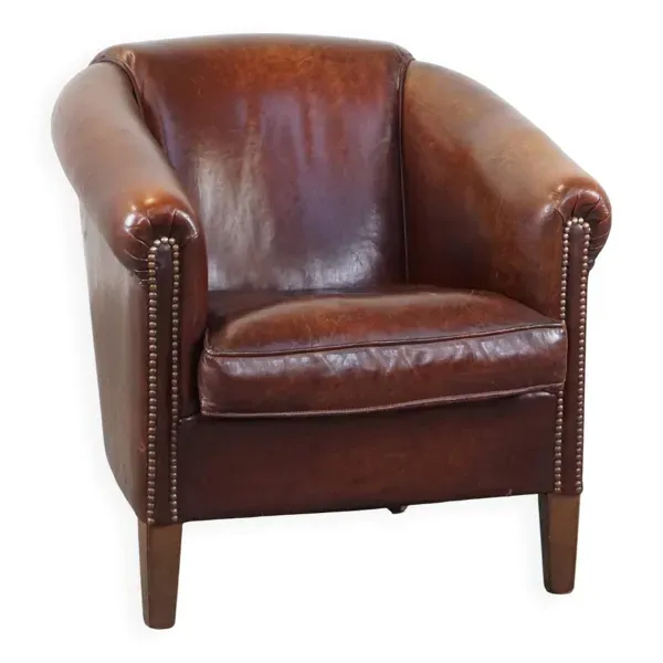 Fauteuil club en peau de mouton, finition soignée avec clous décoratifs