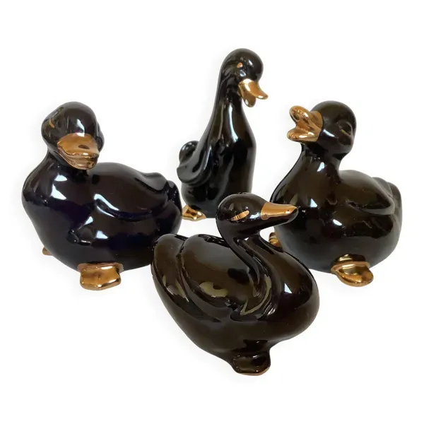 Quatre petits canards noirs et dorés