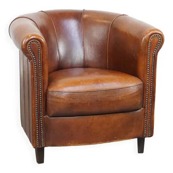 Fauteuil club en cuir de mouton de couleur cognac et finition passepoilée