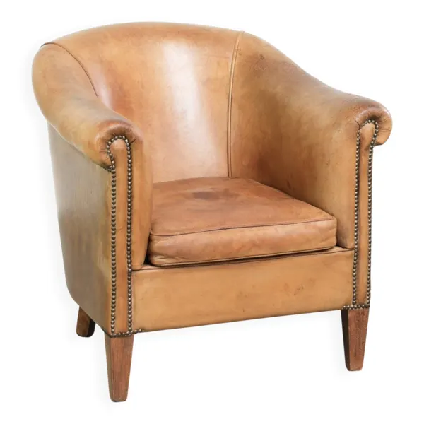 Fauteuil club en peau de mouton confortable de couleur cognac.