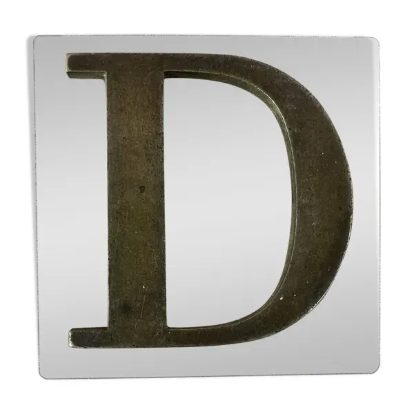 Lettre D en métal sur plaque de verre