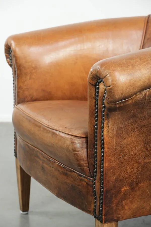 Illustration numéro 2 du produit Fauteuil club en peau de mouton vintage dans une taille subtile avec des couleurs chaudes.