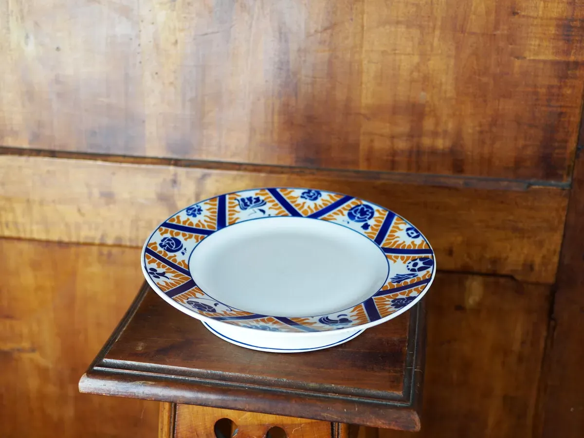 Illustration numéro 2 du produit Plat à gâteau en faïence à motif de fleurs, nuages et flammes, orange et bleu - Orchies - 50s