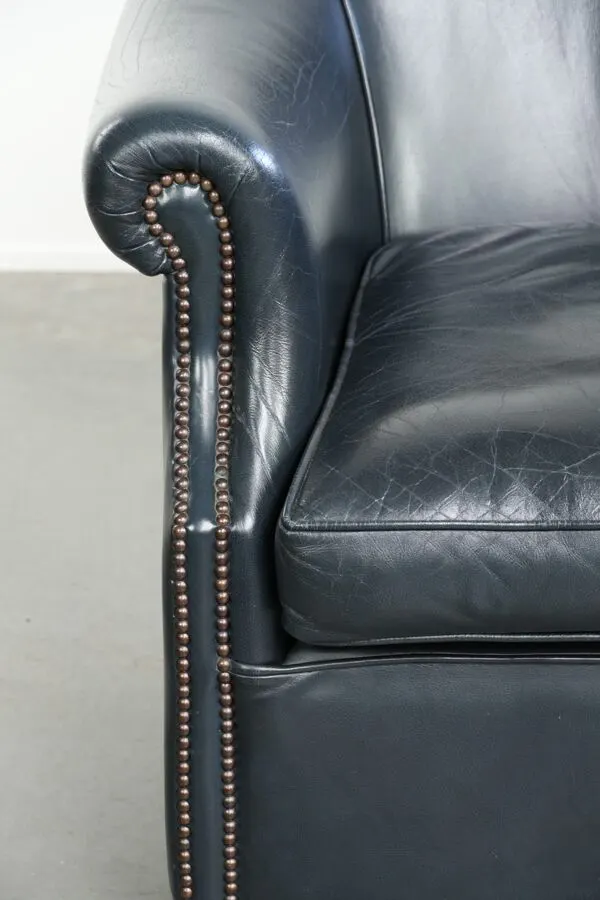 Illustration numéro 2 du produit Fauteuil de club bleu foncé en cuir de vachette au design intemporel.
