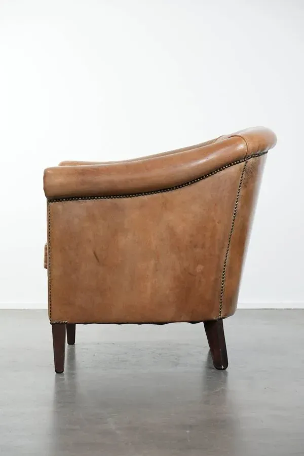Illustration numéro 2 du produit Fauteuil au caractère unique en cuir de mouton avec des couleurs cognac claires.