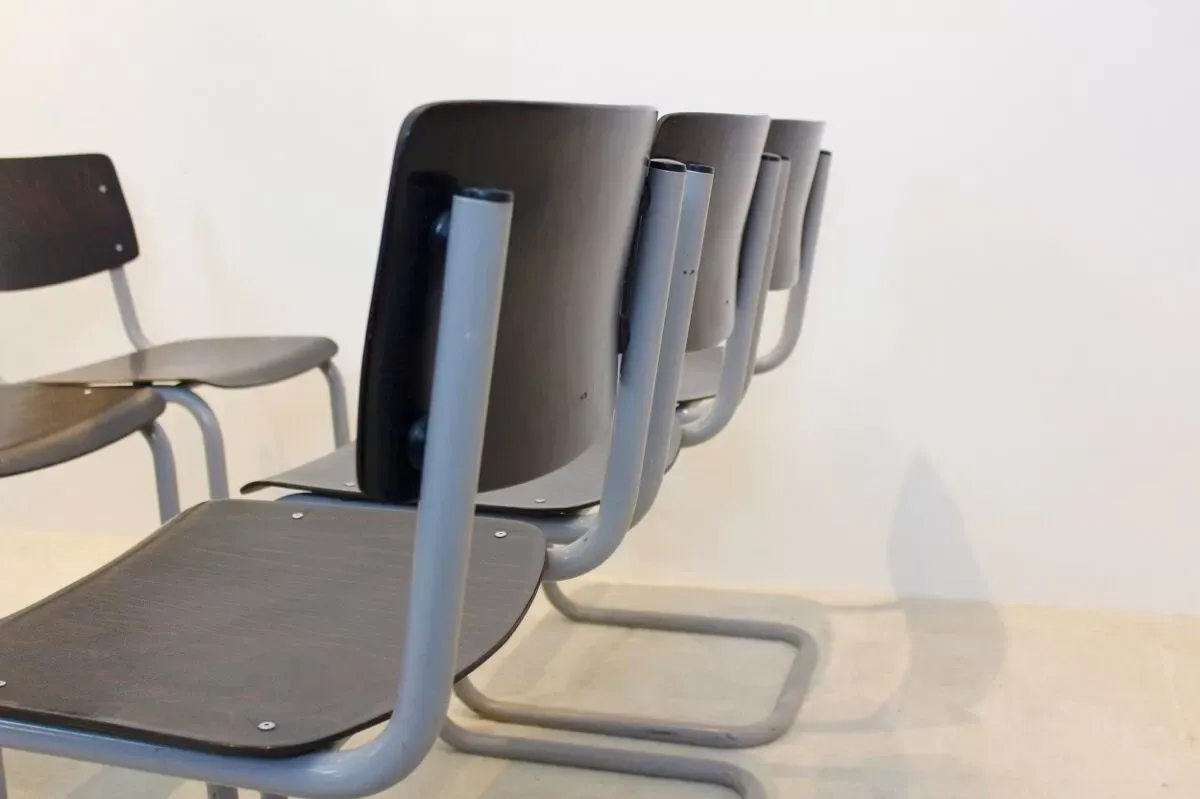 Illustration numéro 2 du produit Ensemble de six chaises industrielles en contreplaqué Gispen dans un cadre gris et wengé.