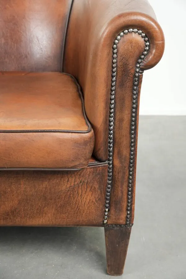Illustration numéro 3 du produit Fauteuil club en peau de mouton avec une belle patine et une finition avec passepoil noir.
