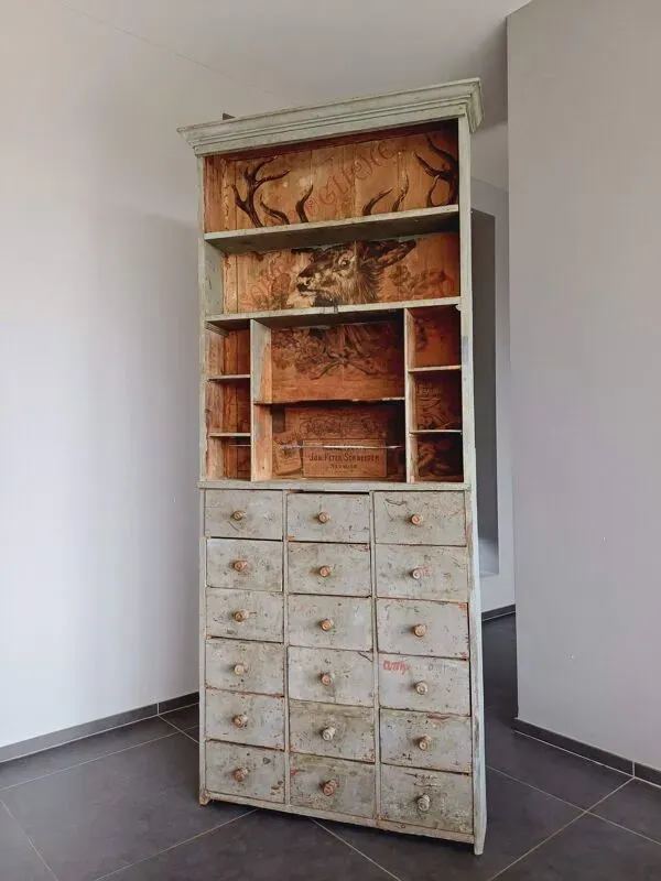 Illustration numéro 3 du produit Meuble de métier à tiroirs avec  très ancienne publicité de tabac en fond