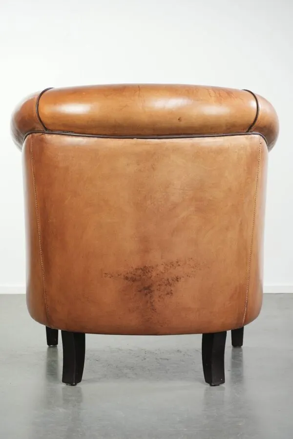 Illustration numéro 3 du produit Fauteuil club en peau de mouton vintage avec une palette de couleurs chaudes et des passepoils noirs.