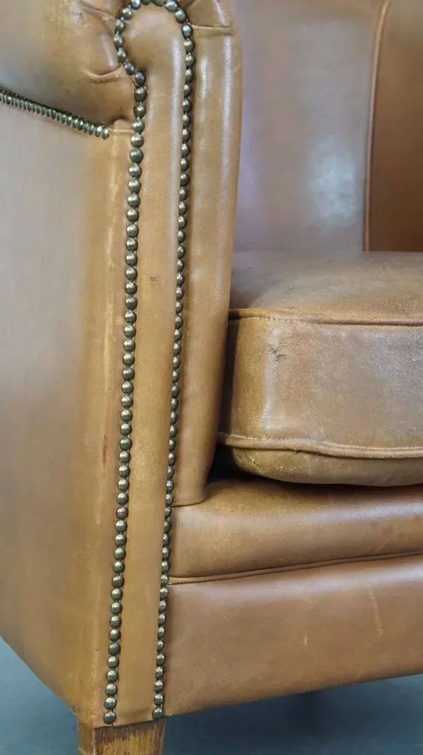 Illustration numéro 3 du produit Fauteuil club en cuir de mouton de couleur cognac neutre et en bon état