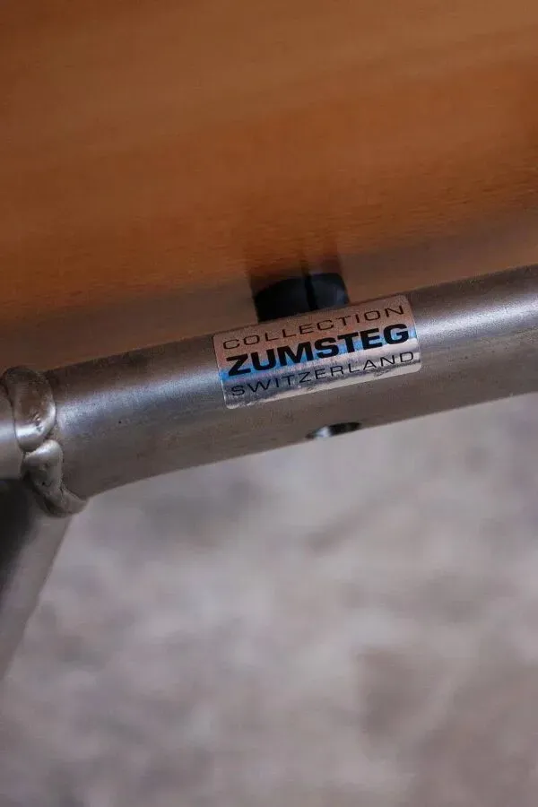 Illustration numéro 4 du produit Ensemble de 4 chaises Zumsteg — Assises en bois clair et structures tubulaires en métal gris, style industriel postmoderne