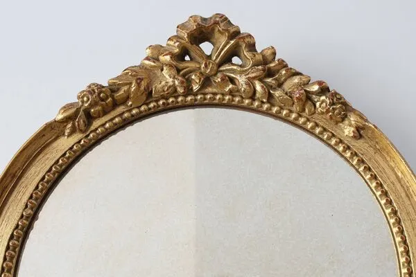 Illustration numéro 4 du produit Miroir ovale en bois doré avec un fronton floral de style rococo, milieu du 20e siècle