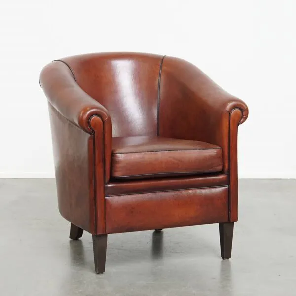 Illustration numéro 4 du produit Fauteuil club en peau de mouton dans une couleur chaude et profonde, fini avec un passepoil noir.