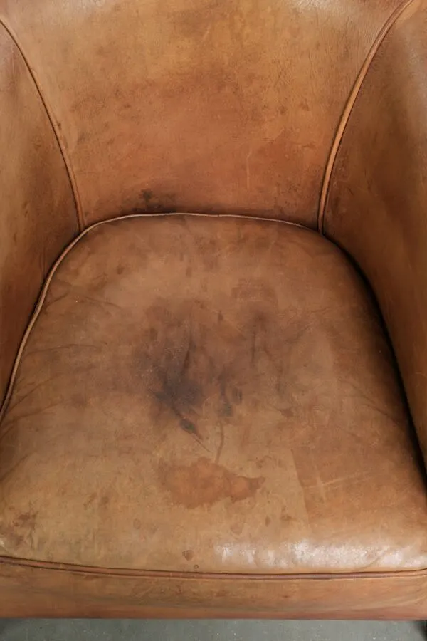 Illustration numéro 4 du produit Fauteuil club en peau de mouton de couleur cognac, fini avec des clous décoratifs.