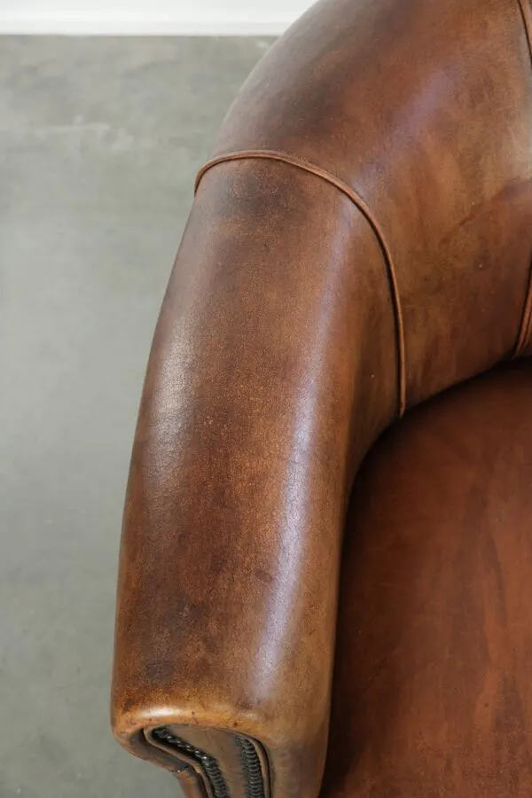 Illustration numéro 4 du produit Fauteuil club en peau de mouton avec une belle patine, fini avec des clous décoratifs.