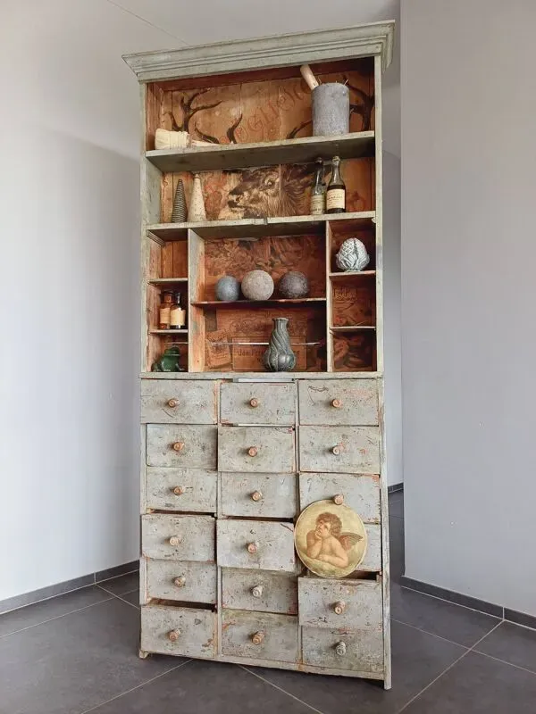 Illustration numéro 4 du produit Meuble de métier à tiroirs avec  très ancienne publicité de tabac en fond