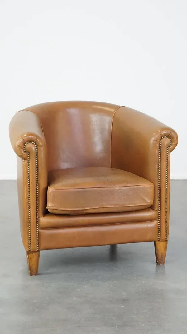 Illustration numéro 4 du produit Fauteuil club en cuir de mouton de couleur cognac neutre et en bon état