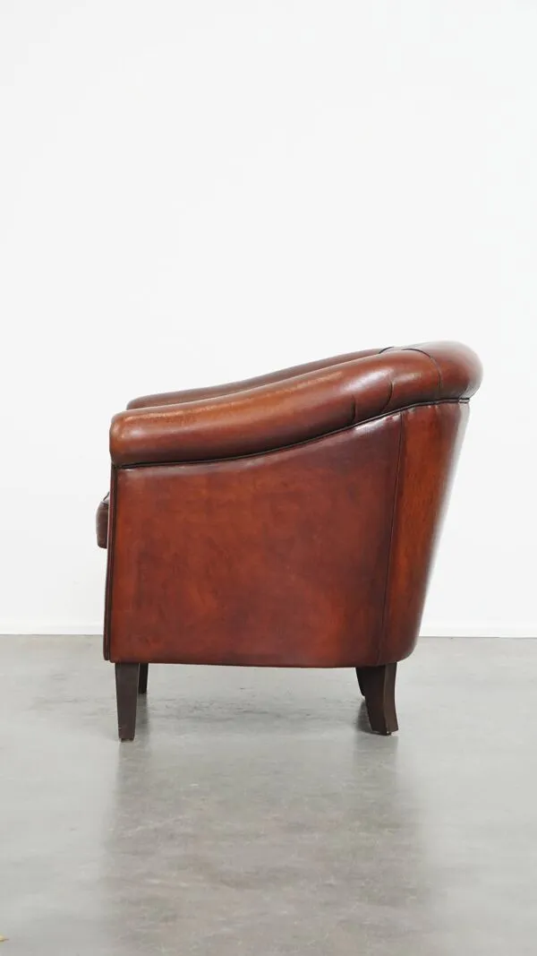 Illustration numéro 5 du produit Fauteuil club en peau de mouton dans une couleur chaude et profonde, fini avec un passepoil noir.