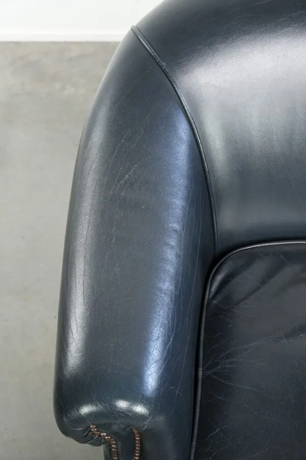 Illustration numéro 5 du produit Fauteuil de club bleu foncé en cuir de vachette au design intemporel.