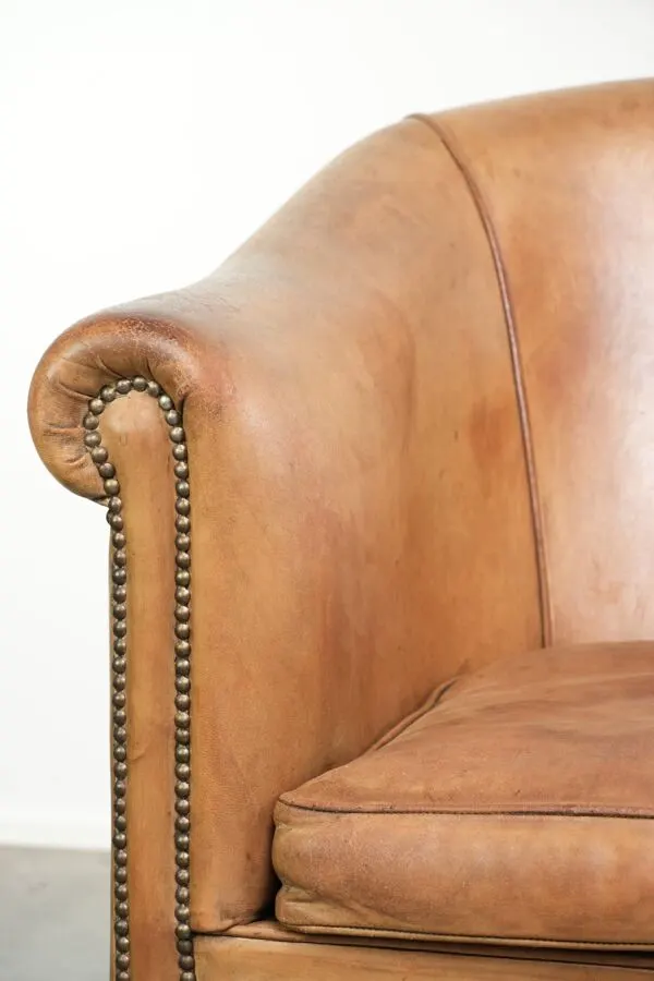 Illustration numéro 5 du produit Fauteuil club en peau de mouton confortable de couleur cognac.